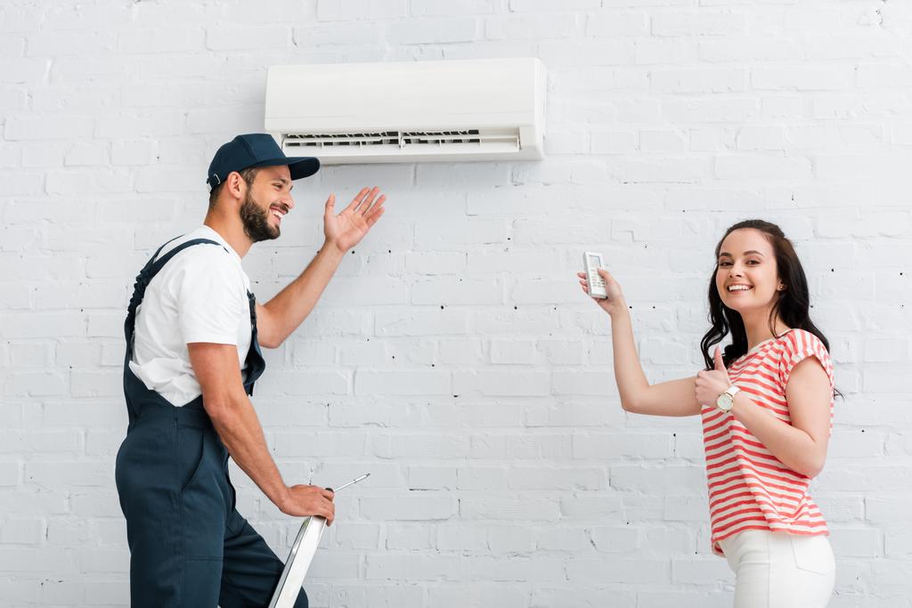 Side View Smiling Woman Remote Controller Air Conditioner Showing Thumb