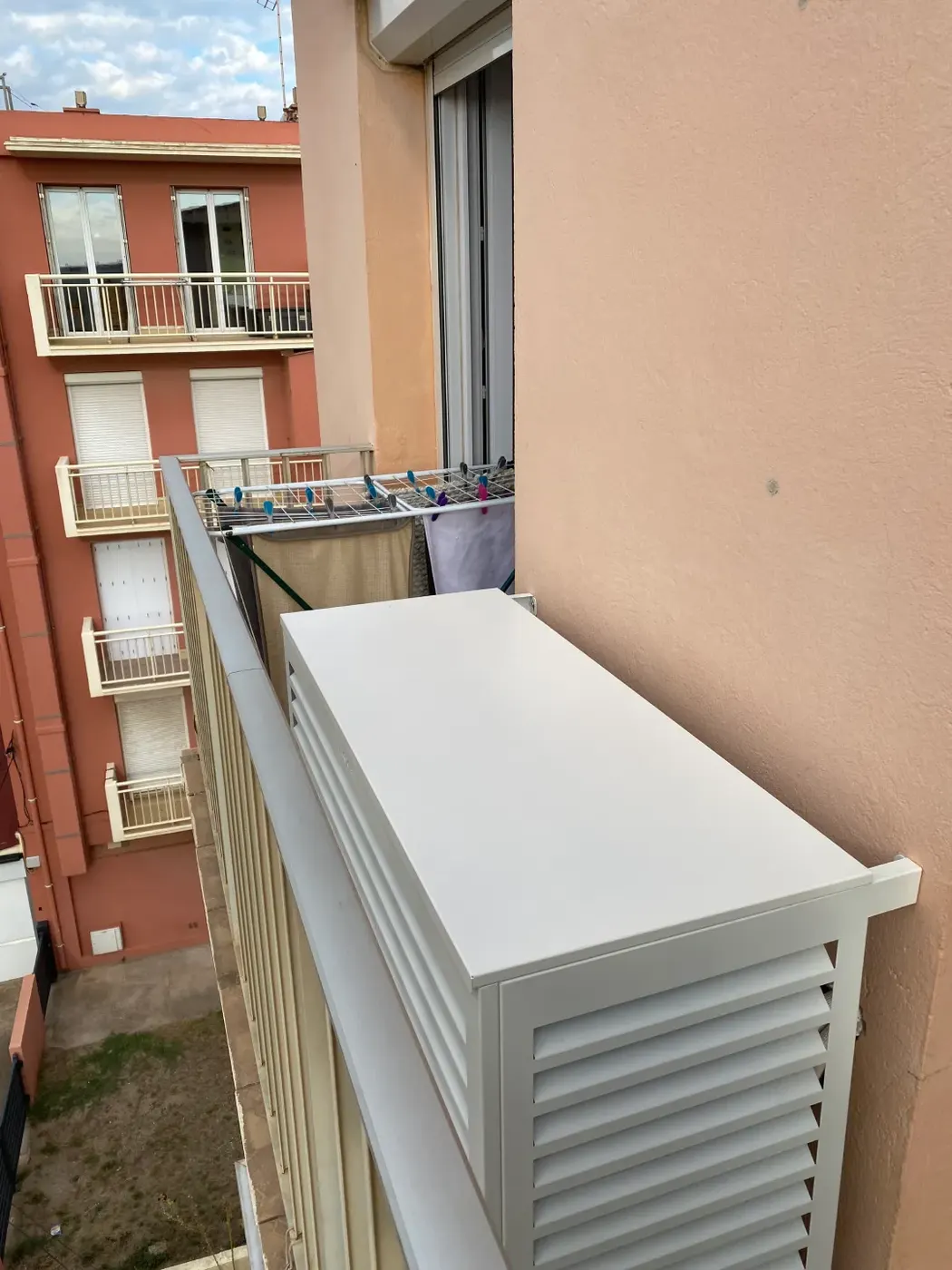 Cache de climatisation installé sur un balcon