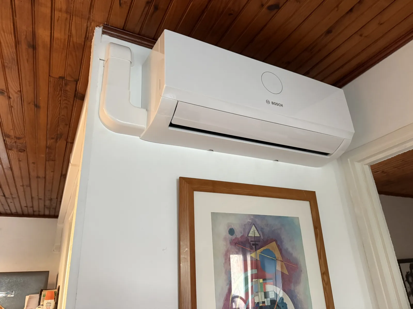 Climatisation Bosch installée au-dessus d’une porte